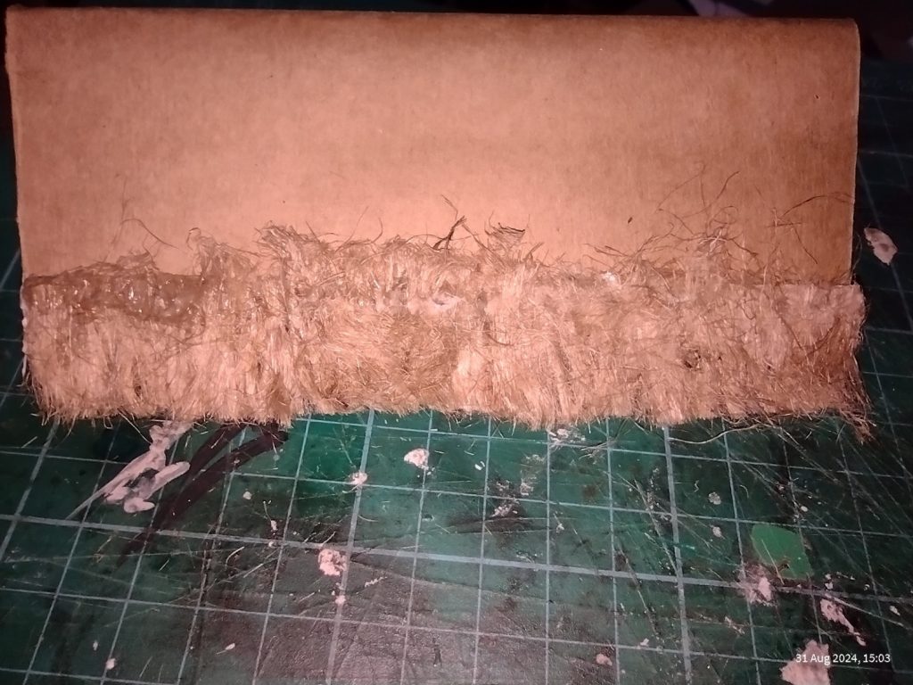 Strip of twine 'thatch' added to model roof