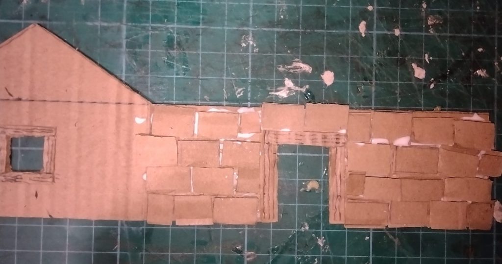 cardboard cottage with bricks added