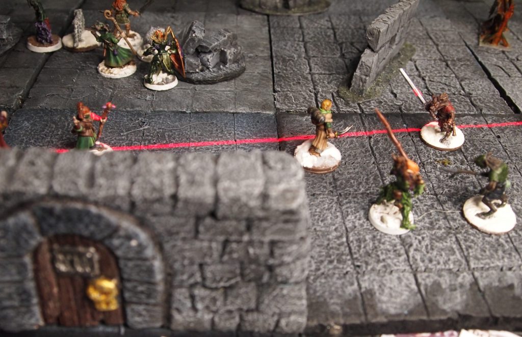 Miniatures on a wargames board for the Frostgrave skirmish wargame and a laser line marker