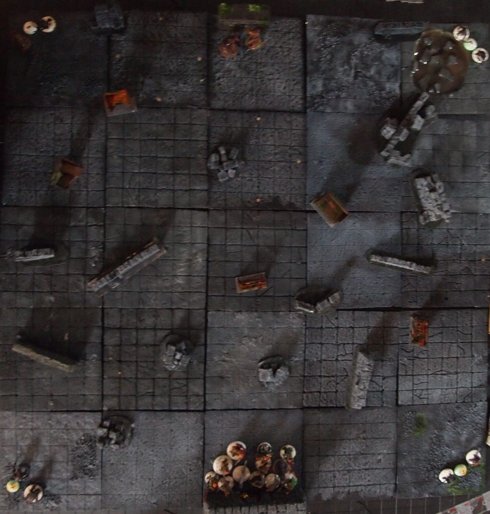 Wargames table covered with xps foam dungeon tiles xps rubble, walls and weapon racks made from coffee stirers.