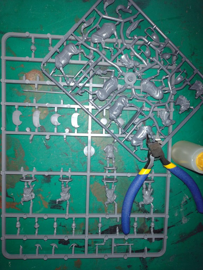 A cutting mat, sprue of miniatures and cutting tools.