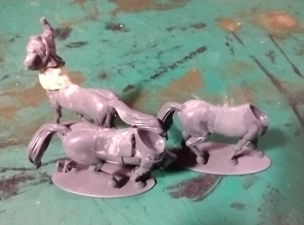 Three horse bodies one with the javelin man torso and the other two showing where the saddle and tack are being removed.